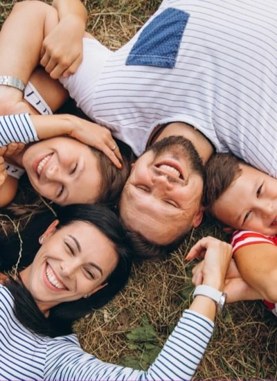 Famille souriante couchée dans un champ